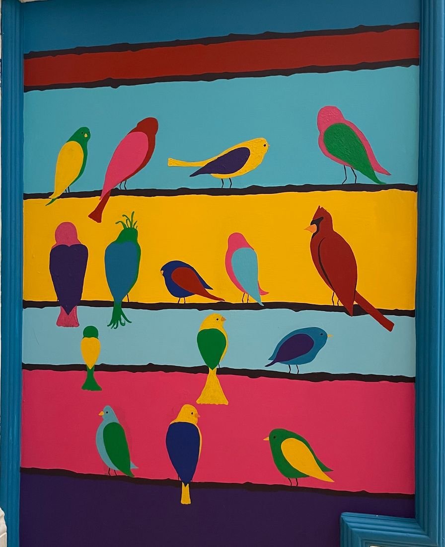 Laundry Room Makeover: a painted mural of colorful birds perched on bold horizontal stripes